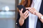 Closeup image of a businesswoman holding and using mobile phone