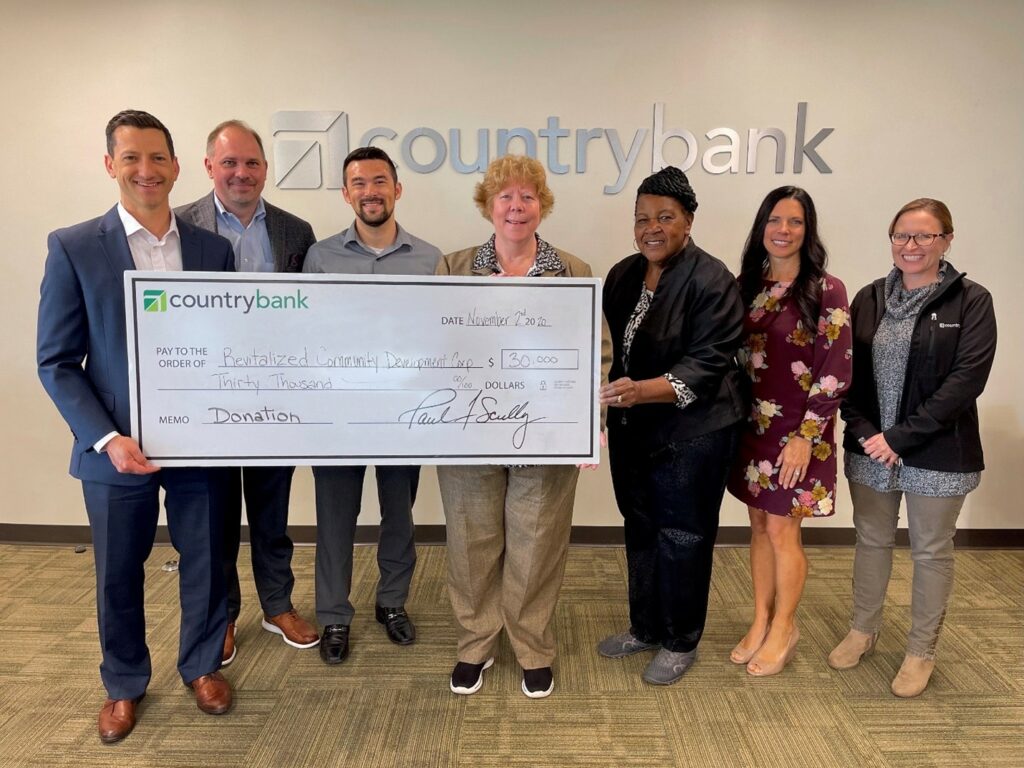 Ben Leonard, Ryan Nauman and Sam Pursey from Country Bank, Revitalize Community Development Corporation President & CEO Colleen Shanley-Loveless and Director of #GreeNFit Program Ethel Griffin, Jodie Gerulaitis and Sarah Yurkunas from Country Bank pose with a presentation check for $30,000 in front of Country Bank logo