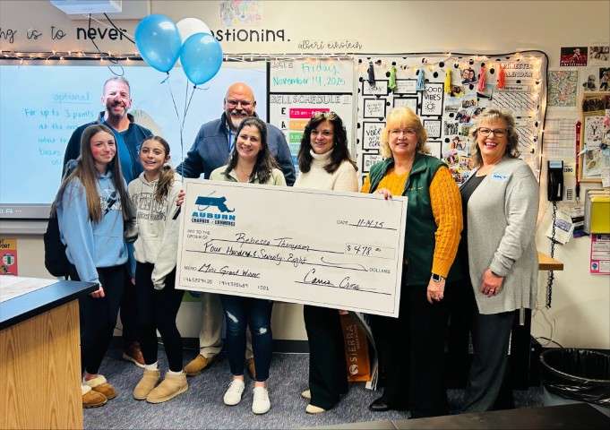 Image of Rebecca Thompson receiving a check from the Auburn Chamber of Commerce